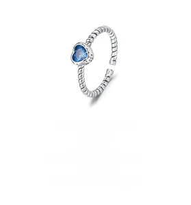 Macro detail of S925 sterling silver twisted band with heart-shaped blue gemstone