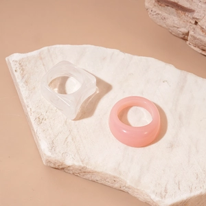 Detail of two-piece acrylic resin rings with marbled texture on a marble surface