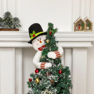 Whimsical snowman Christmas tree topper hugging a decorated holiday tree centerpiece.