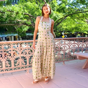 Elegant backless halter maxi dress with green palm leaf print and layered pleated skirt