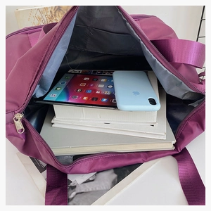 Top view of spacious purple travel bag interior showing tablet and books storage