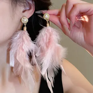 Pink feather long drop earrings with pearl stud details shown on model for a sweet style