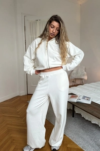 Detail of white cropped zip-up hoodie and high-waisted wide-leg sweatpants set