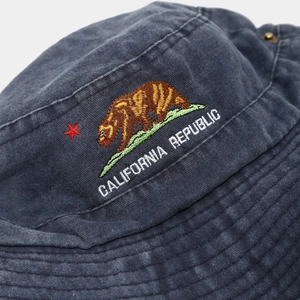 Close-up of California Republic bear embroidery on washed denim blue bucket hat