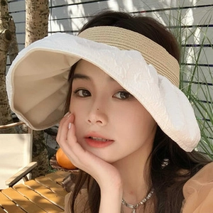 Gros plan d'un chapeau de soleil à large bord avec bandeau tressé et tissu plissé blanc