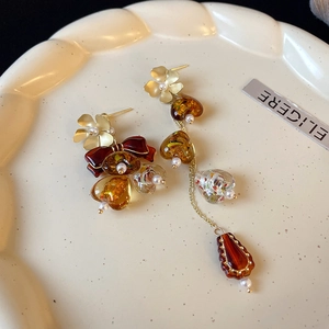 Detailed view of vintage gold floral earrings with amber stones and heart beads