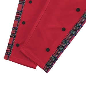 Detail of men's casual pants showing side plaid patchwork and black snap buttons