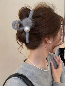 Detail of grey flocked shark hair claw clip with plush balls and white faux pearls