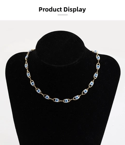Detailed shot of golden evil eye beaded chain on black jewelry mannequin display