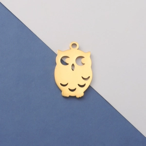 Macro shot of owl-shaped golden stainless steel pendant with hollow-out design details