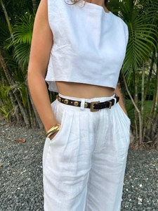 Detail von weißem Leinen-Set aus Crop-Top und High-Waist-Hose mit goldenem Gürtel