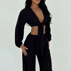 Ensemble chic noir deux pièces avec haut court à lacets col V et pantalon plissé taille haute