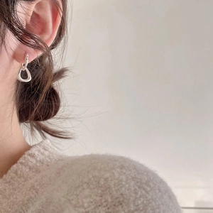 Close-up of minimalist S925 sterling silver hoop earrings worn on model's ear