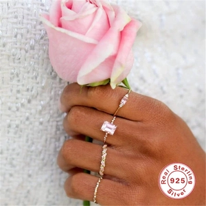 Detail of four 925 sterling silver gold rings with pink gemstones and rose