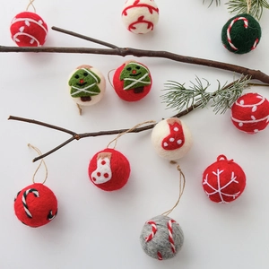 Handmade wool felt Christmas ornaments set with festive snowflakes and trees on white background
