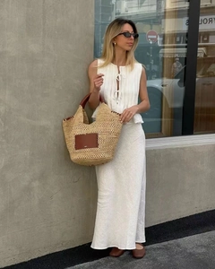 Chic summer outfit featuring a pleated sleeveless top with a large straw tote bag