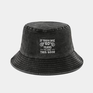 Macro detail of washed black cotton bucket hat with white 60th birthday embroidery text