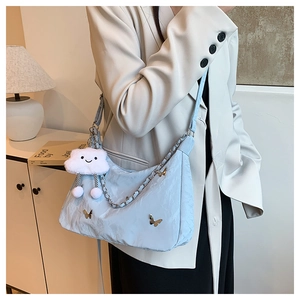 Close-up of light blue pleated handbag with silver chain and butterfly charm decoration