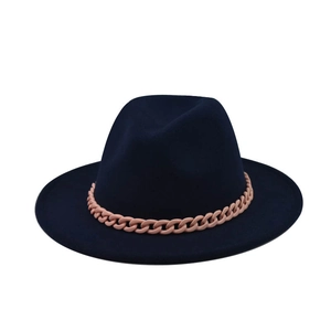 Detail of dark blue wool fedora hat featuring a chunky pink chain decorative band