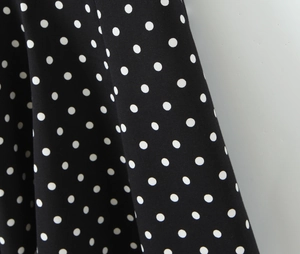 Gros plan sur la texture du tissu à pois noir et blanc montrant le drapé et la matière