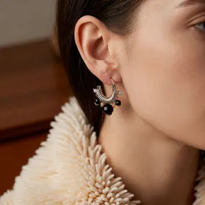 Vintage C-shaped tassel earrings with silver finish and black beads worn by a model