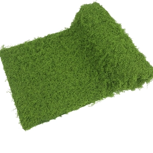 Close-up of artificial green moss turf with dense fiber texture for landscape decoration