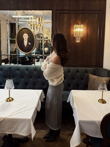 Détail d'une robe vintage à carreaux et dentelle dans un décor de restaurant luxueux