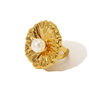 Makro-Detailansicht des goldenen Faltenblumenrings mit großer weißer Perle in der Mitte