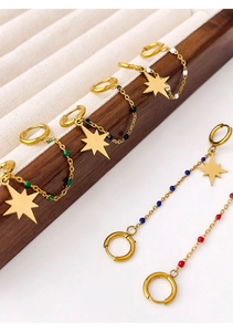 Detail of colorful eight-pointed star earrings with gold chain on wooden jewelry stand