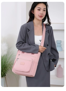 Pink multi-pocket oxford cloth crossbody bag shown on a model in a casual setting