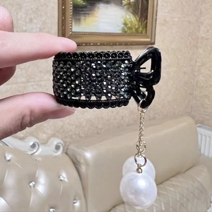 Detail of black rhinestone hair claw with hanging gold chain and white pearl pendants