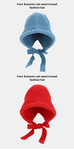 Detail of red and blue chunky knit earflap hats with long decorative tie straps