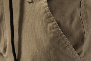 Close-up of khaki cargo pants showing heavy cotton twill texture and reinforced double stitching