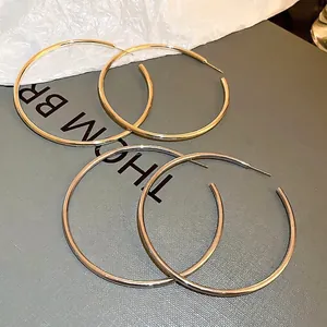 Minimalist exaggerated large hoop earrings in metallic gold and silver tones
