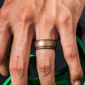 Close-up of a bronze silicone athletic ring worn on a finger during outdoor fitness