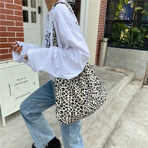 Detail of trendy large leopard print canvas tote bag carried over the shoulder