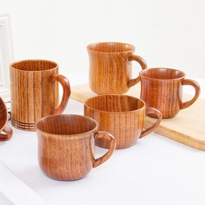 Handcrafted jujube wood coffee mugs with natural grain and handles on a wooden board