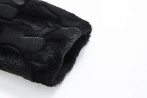 Macro detail of thick black faux fur texture on the coat sleeve with soft glossy finish