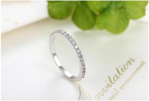 Detailed close-up of a silver ring featuring a thin band with shimmering inlaid crystals