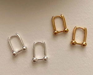 Detail of 925 sterling silver geometric U-link earrings with ball accents in gold and silver