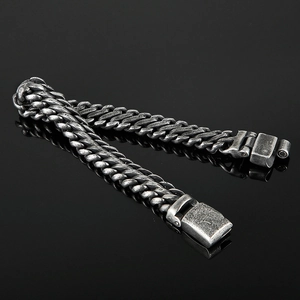 Detail of vintage steel mesh bracelet with industrial clasp on black reflection