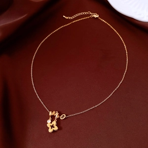 Close-up of 18k gold-plated flower pendant with white zircons on dark brown velvet fabric