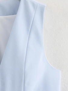 Vue détaillée du tissu tissé bleu clair et de la doublure blanche du gilet court