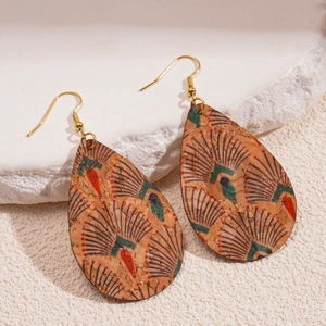Détail de boucles d'oreilles en cuir goutte avec motif plumes de paon sur pierre