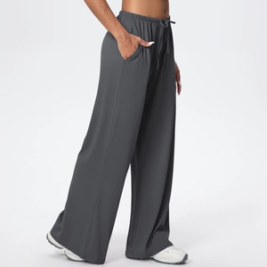 Detail of dark grey wide-leg joggers featuring a drawstring elastic waist and side pockets