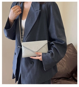 Detailansicht der silbernen Glitzer-Clutch mit eleganter goldener Ketten-Schulterriemen