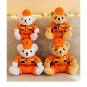 Detail of cute firefighter teddy bears in orange uniforms and caps with 119 logos