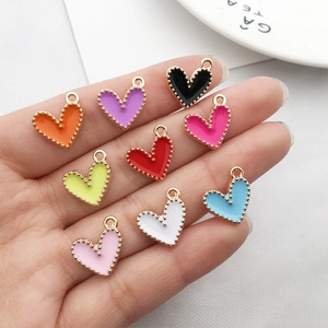 Nine colorful drip oil heart charms in gold alloy displayed on a hand for DIY jewelry
