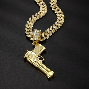 Golden iced out Cuban chain necklace with a realistic desert eagle pistol pendant