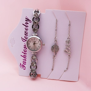 Close-up of a silver quartz watch and two crystal-studded bracelets on display card